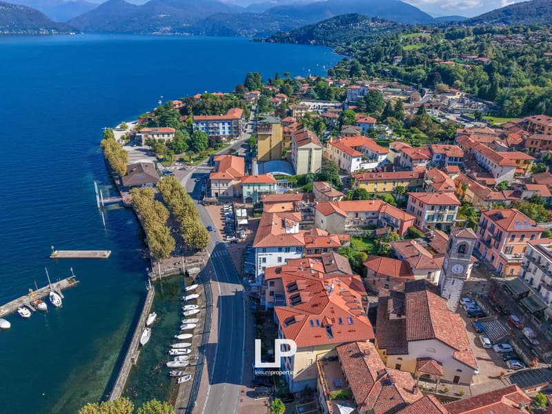 Aerial view of a small town by the lake with buildings, marina, and boats.