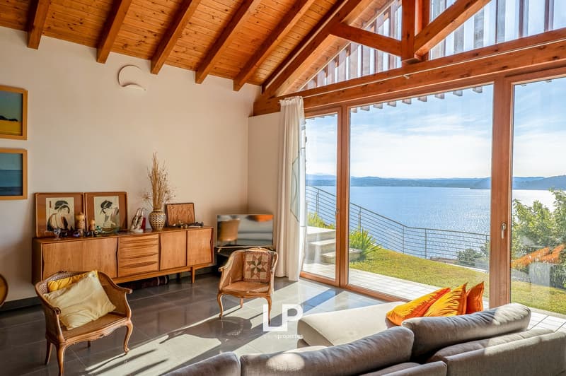 elegant wooden furniture, large white sofa, 2 chairs, decorative objects on the cabinet, floor to ceiling windows, wooden balcony