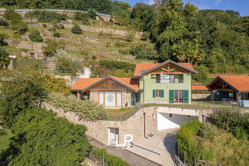 House with raised ground floor, situated in hilly terrain with terraced landscape