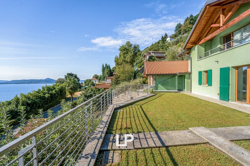 Metal railings, well-maintained grass, a view of a lake and mountains