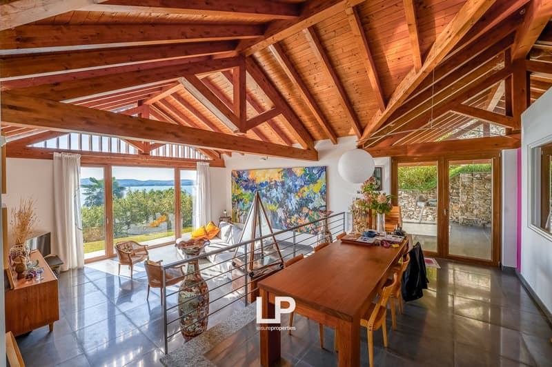 dining area with wooden ceiling and large windows offering a view of the lake and mountains