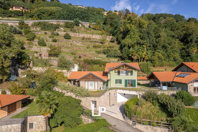 Five interconnected houses, stone walls, wooden roofs, windows, gardens, terraces, stone pathways, lush greenery, terraces