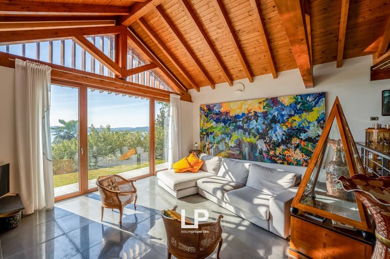 wooden ceiling, sliding glass doors to a terrace, modern sofa, artwork, tiled floor, glass furniture