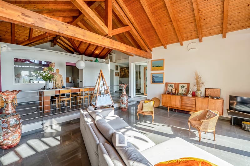 living room with wooden ceiling, couch, wooden tables, cabinets, wooden furniture, TV, vases, and windows