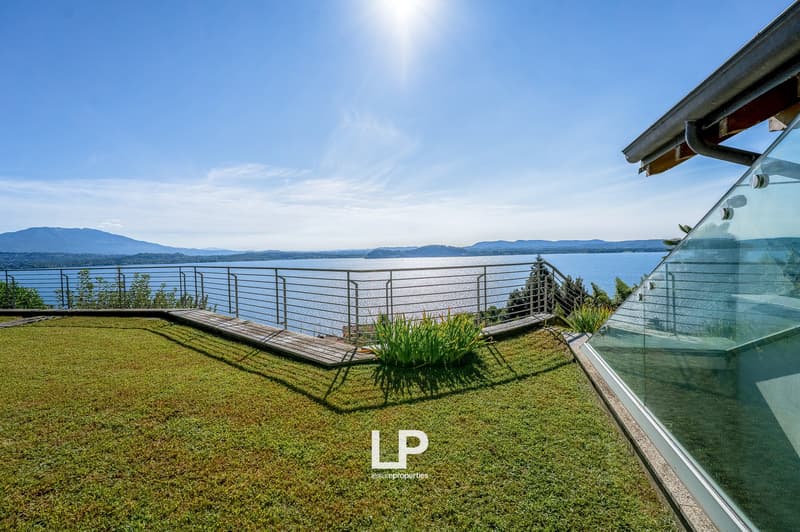 modern building with glass facade, wooden deck, fence, beautiful sea view