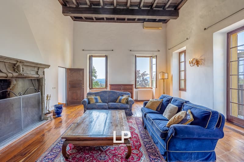 wood floor, blue couches, coffee table, fireplace, windows