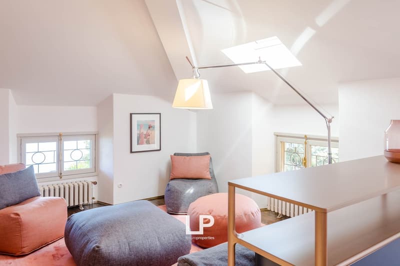 upstairs room, minimalistic decor, couches, bean bags, two windows, skylight, modern lighting