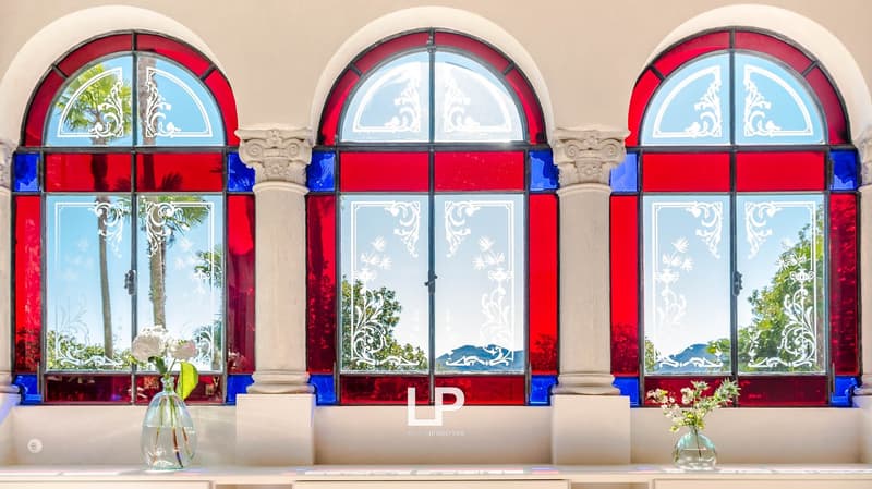 Three stained glass windows, floral designs, view of the mountains