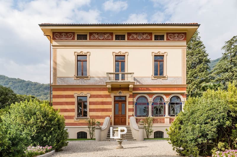 stucco decoration, glass windows, two story, beige wall, brown door, balcony