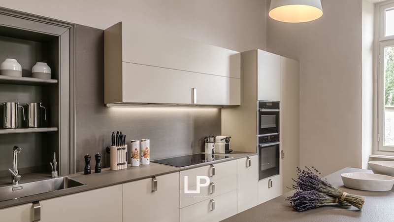 Modern white cabinets, modern stainless steel appliances, gas cooktop, sink, open shelf, bright lighting