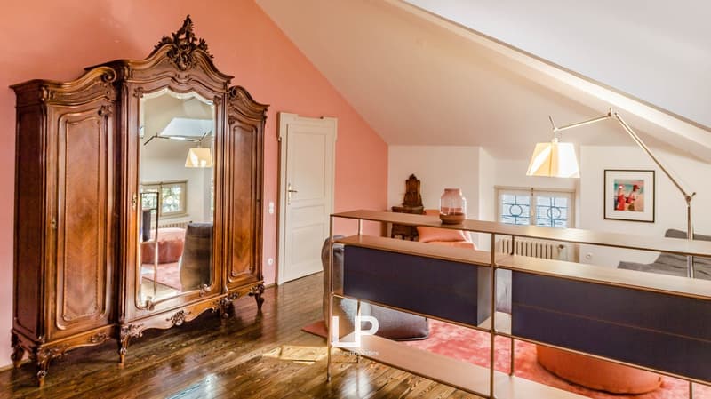 wooden floor, pink walls, large mirror, elegant wardrobe, beige sofa, orange armchair, desk, shelves, lamps, picture frame, small objects, framed mirror on wall