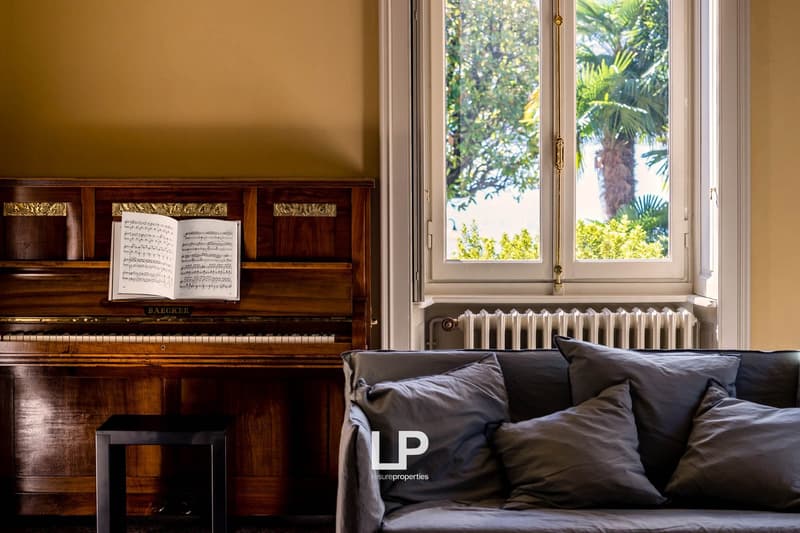 room with piano, couch, windows, radiator