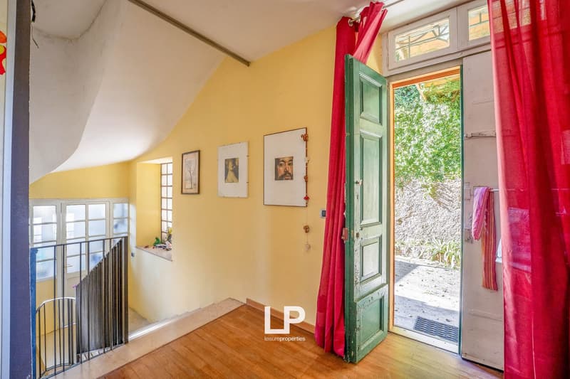 Corridor, yellow walls, wooden floor, metal handrail, open door, pictures, curtains
