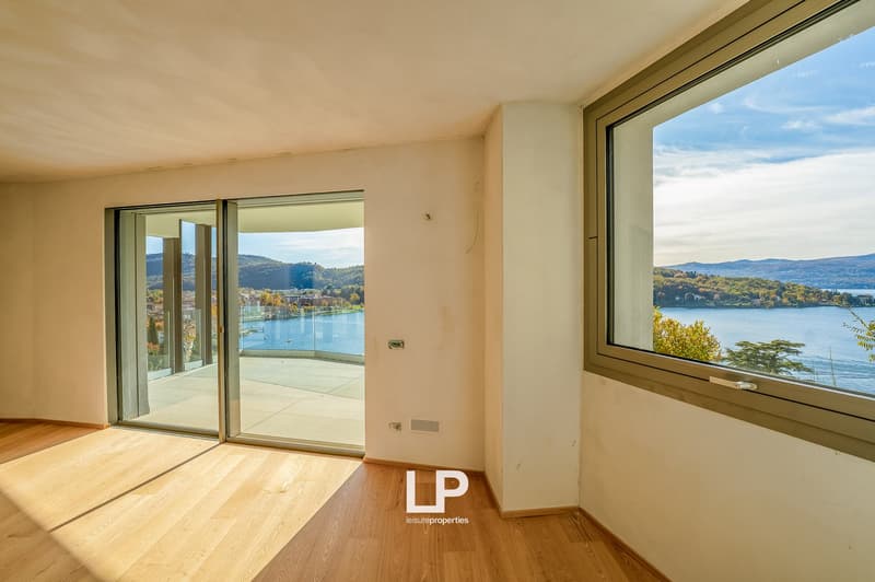 wooden floor, sliding glass doors leading to terrace, large window with lake view