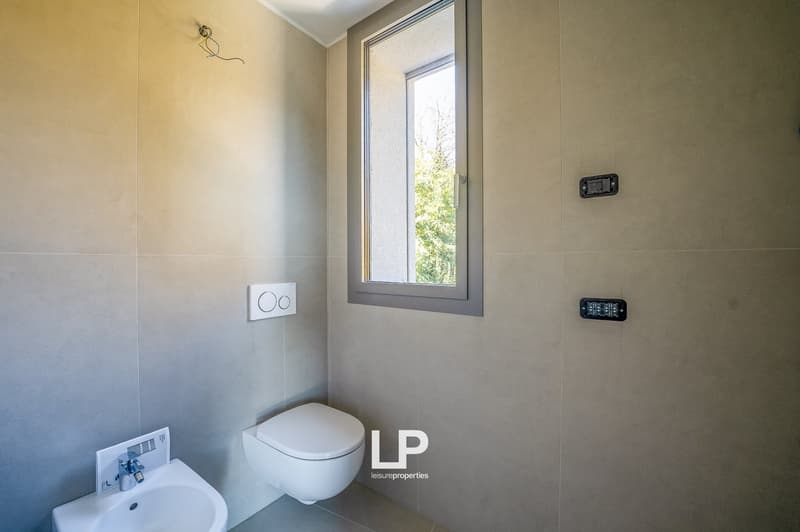 modern bathroom, white toilet, white sink, tiled walls, small window