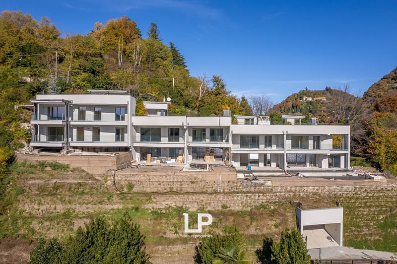 Modern residential building, white exterior, glass windows, balcony, under construction