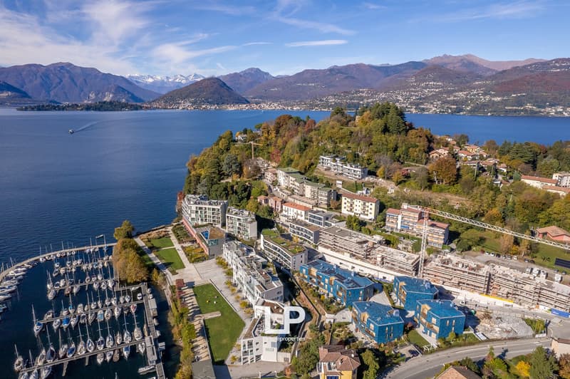 Aerial view of a town with buildings, mountains, and a lake