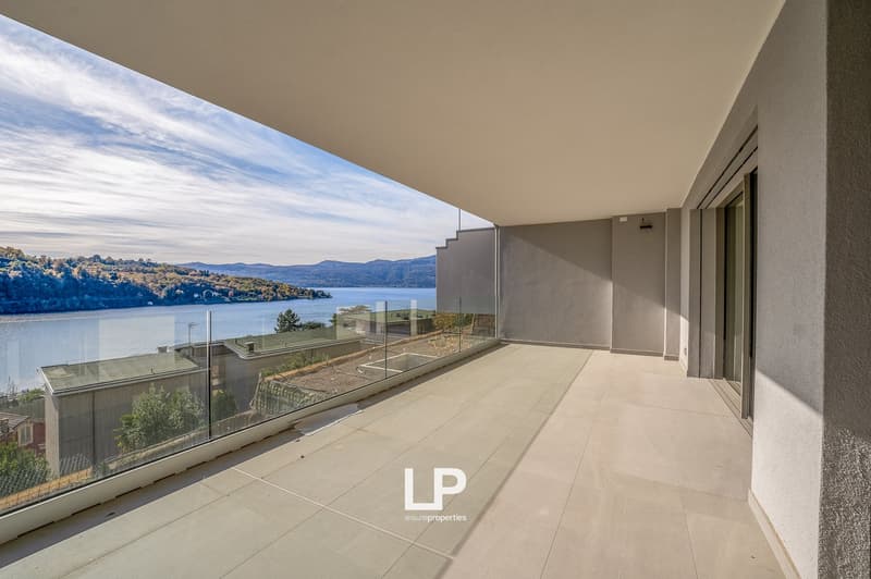 terraced balcony, tiled floor, glass railings, distant view of lake and mountains