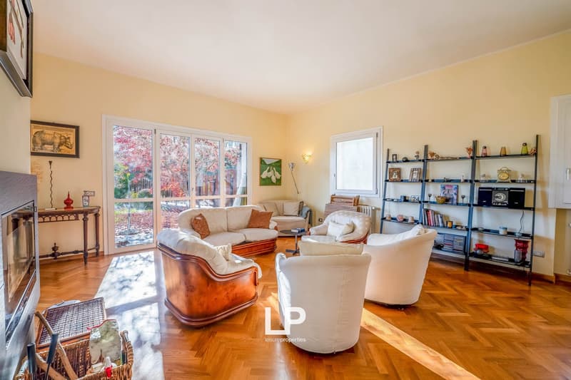 wooden floor, fireplace, couch, armchairs, shelves, lamp, painting, picture frame