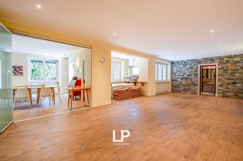 modern interior, wooden flooring, dining area with table and chairs, wall-mounted clock, open space