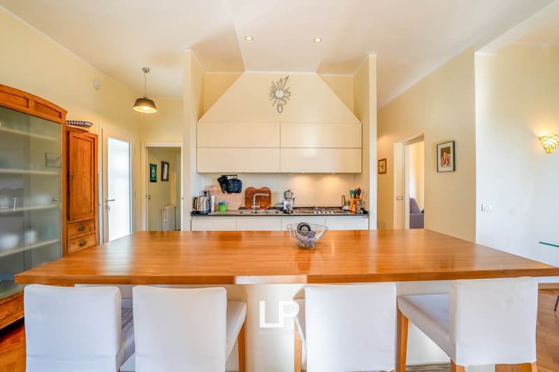 kitchen area with island, white countertops, wooden island, white chairs, cabinets, tiled floor, kitchen appliances, decor items
