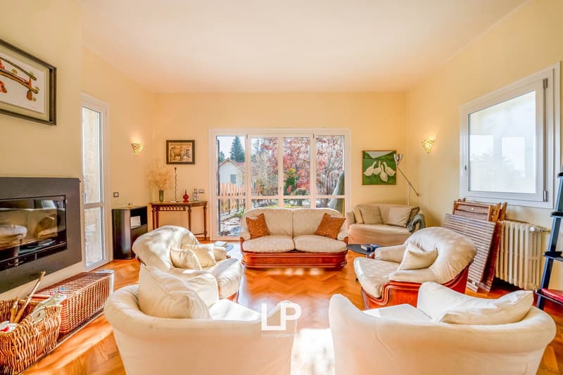 living room with a fireplace, sofas, center table, window with glass door, picture frames on the wall