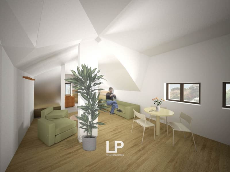 Interior with sloped ceiling, green couch, wooden coffee table, flower vase, wooden floor