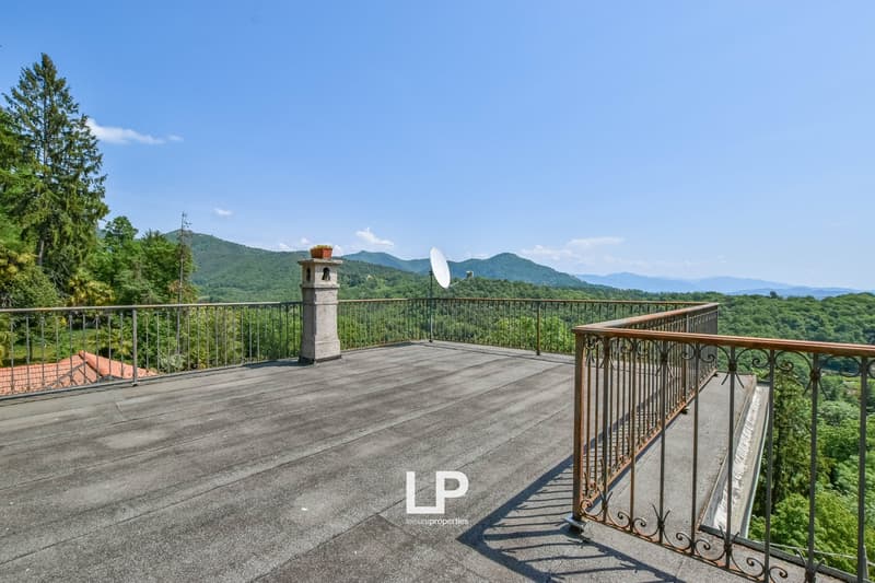 Terrace with wooden floor, railing, chimney, satellite dish, scenic view, greenery