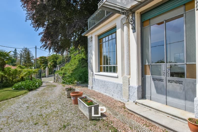 house, white walls, glass windows, gray doors, gravel path, potted plants, garden, balcony