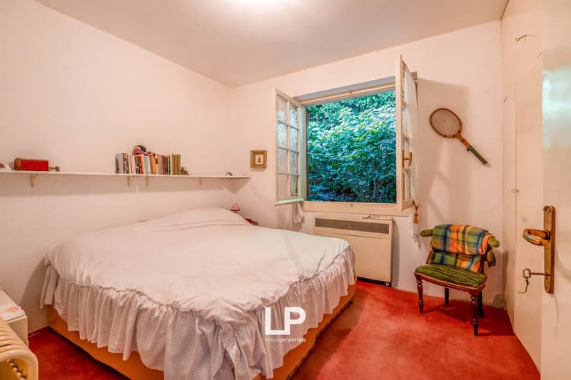 white walls, bed, chair, bookshelf, radiator, open window