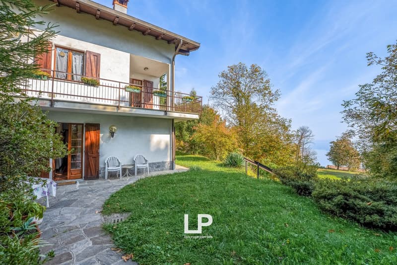2 story house, balcony, patio with chairs, outdoor garden, view of the lake