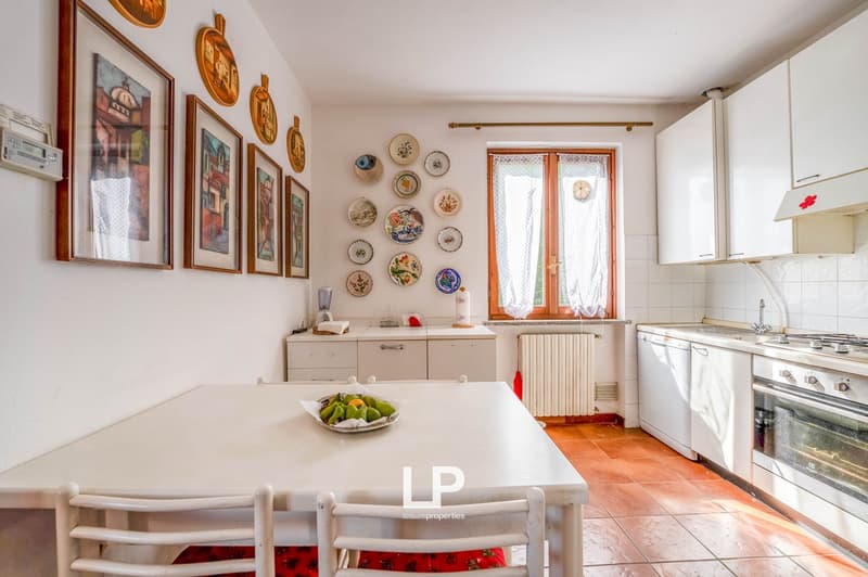 kitchen with dining area, modern style, tiled floor, white cabinets, hanging art pieces, white table, white chairs