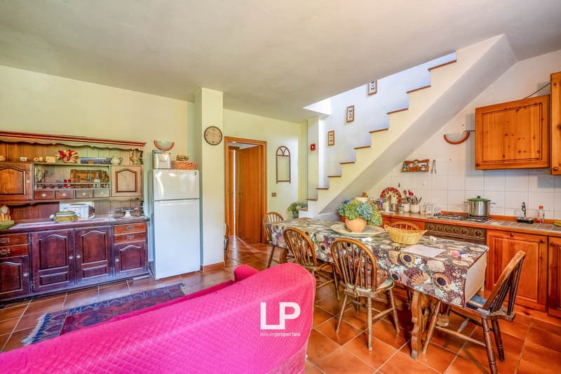 kitchen with wooden furniture, dining table, and pink sofa