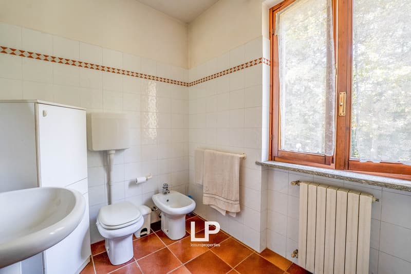 White tiles, toilet, bidet, sink, window, radiator
