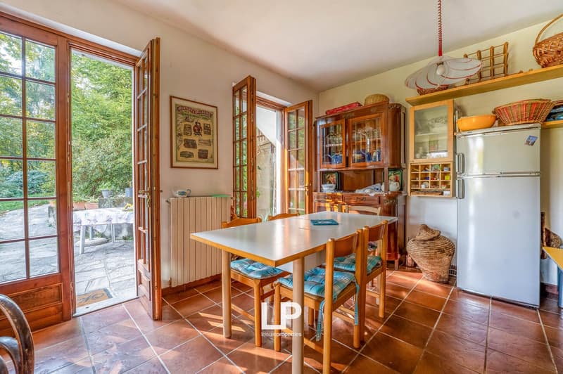 dining room, wooden dining table, wooden chairs, tiled floor, French windows, radiator, shelves, wooden cabinets, refrigerator