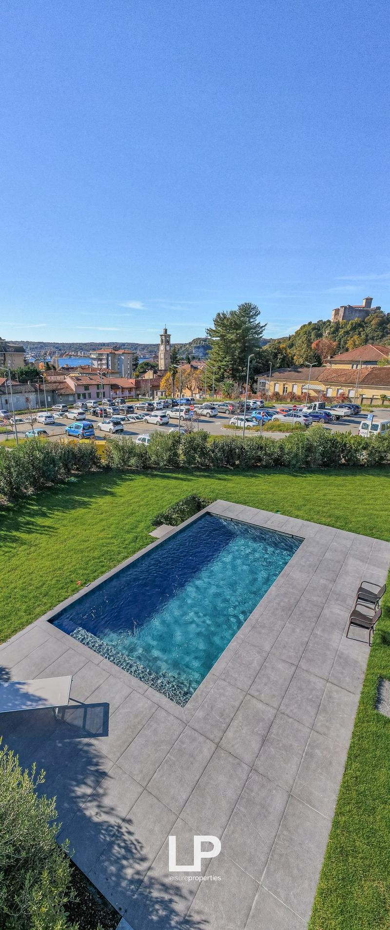 Swimming pool, grass, lounge chairs, view of town and sea