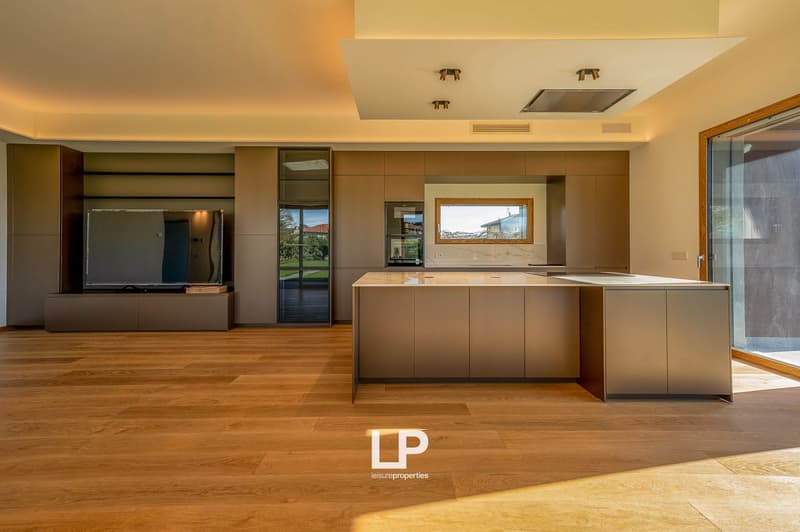 modern kitchen with island, TV, glass doors