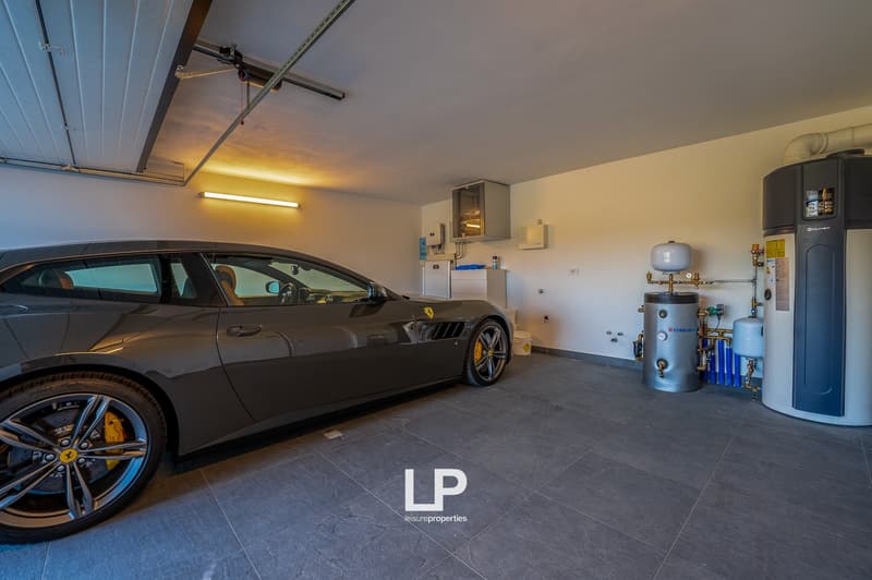 Gray sports car parked, tile flooring, metal pipes, white storage boxes, water heater, heater