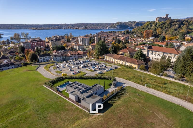 buildings, parking lot, swimming pool, grassy areas, waterfront view