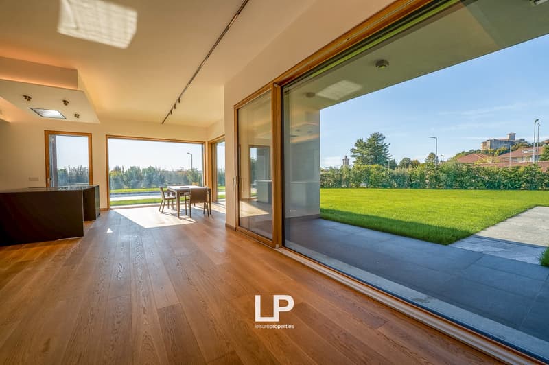 large windows, hardwood floors, modern kitchen with table, sliding glass doors to balcony