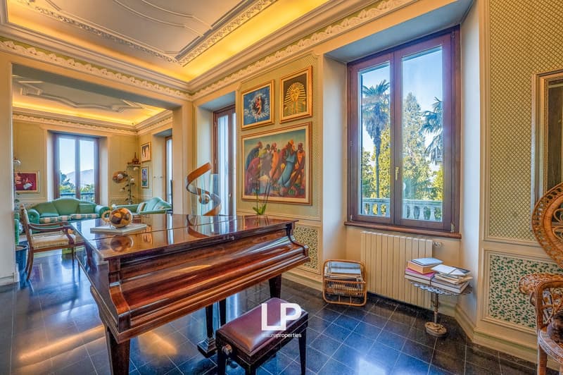 large piano, wooden chair, radiator, windows, decorative paintings, furniture, floor lamp