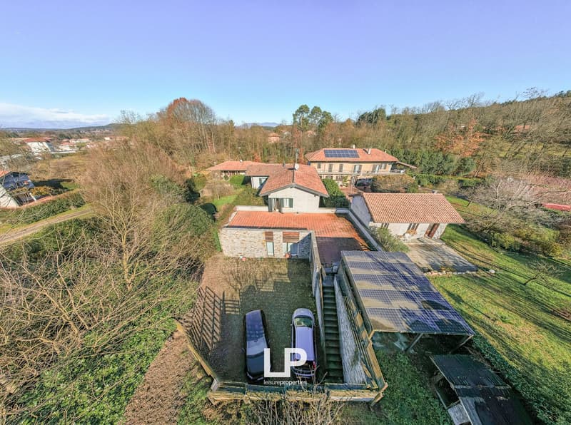 Complex of buildings, multiple houses, parking spaces, solar panels, fenced yard