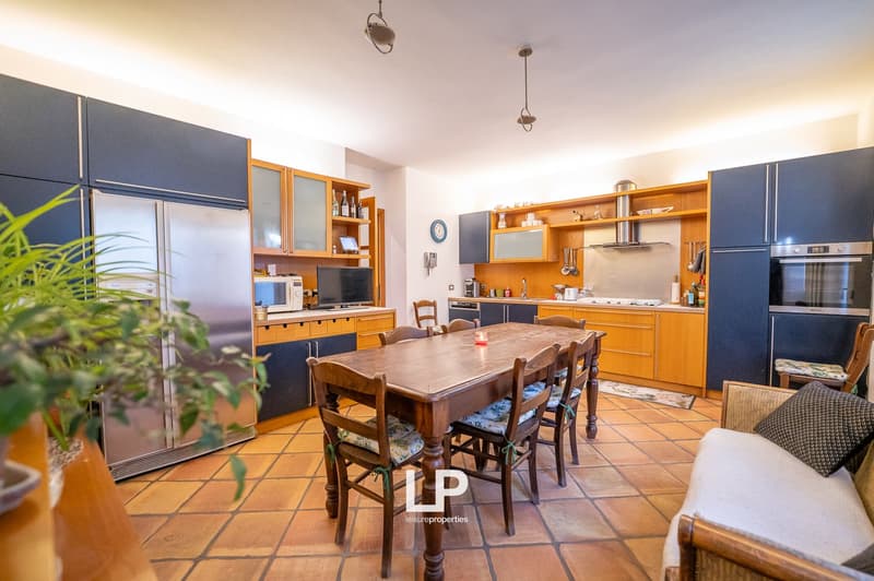 kitchen area with wooden dining table, stainless steel fridge, built-in shelves, microwave, toaster, cooker, and dining chairs
