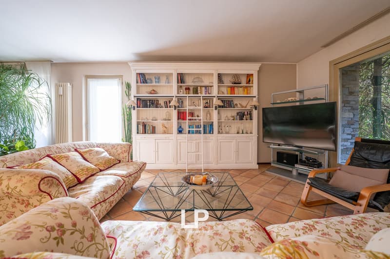 white sofa, glass table, large bookshelf, television, bowl of candles