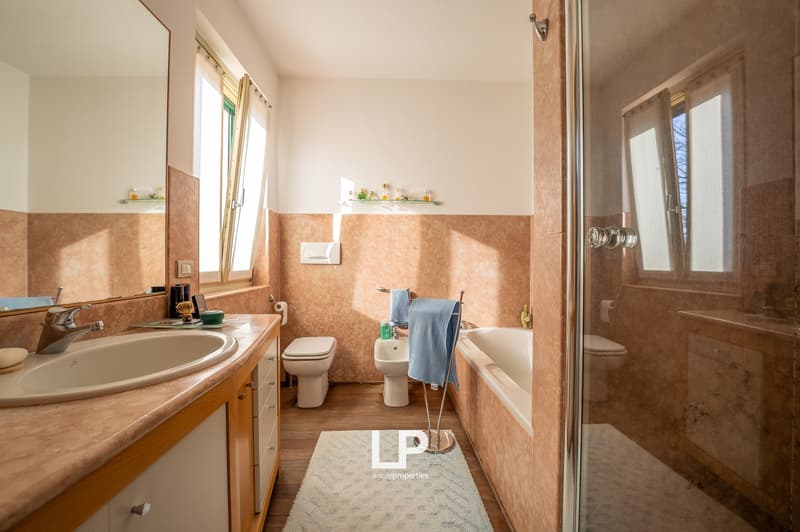 bathroom with bathtub, sink, mirror, toilet, bidet, and wooden floor