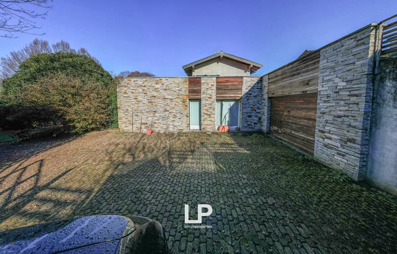 2 story brick house, garage on the right, driveway with brick surface