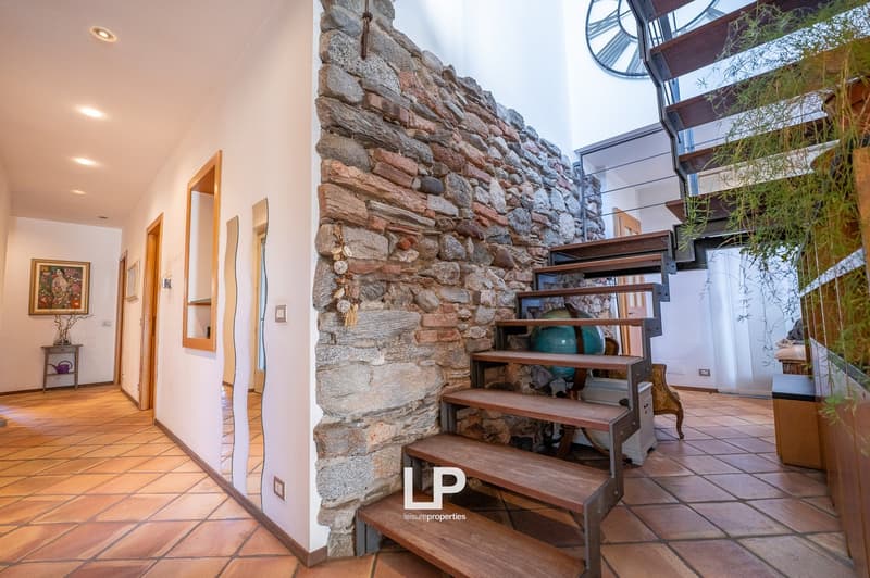 stone wall, wooden stairs, terracotta tiles, artwork on wall