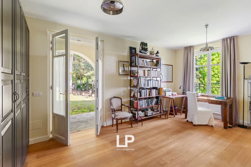 wooden floor, open doorway, bookcase, desk, chair, windows with curtains, view of garden