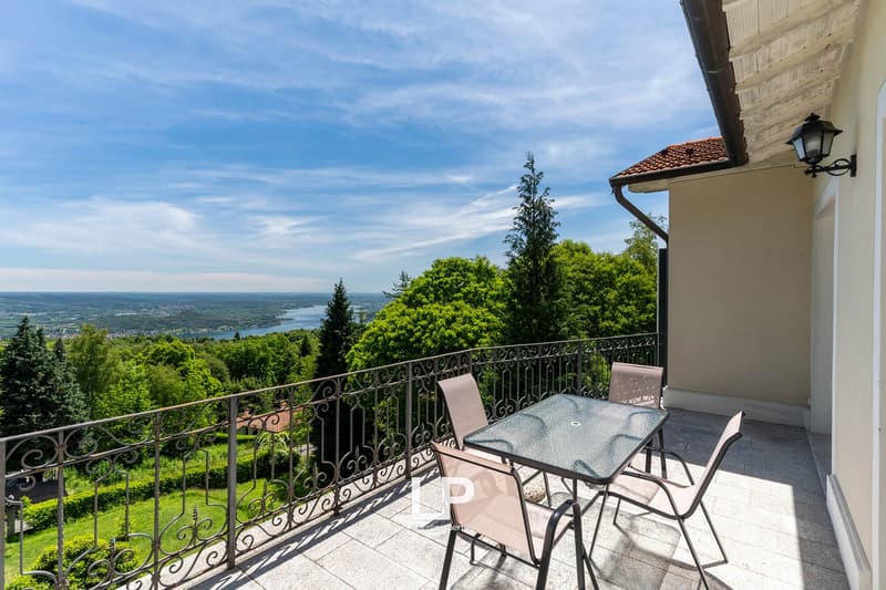 balcony with metal railing, table and chairs, overlooking a beautiful landscape