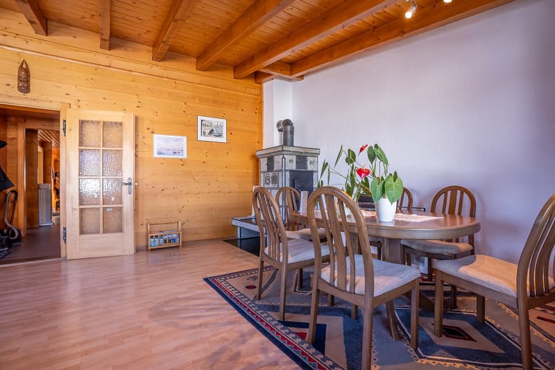 round dining table, wooden chairs, wood paneling, fireplace, rug